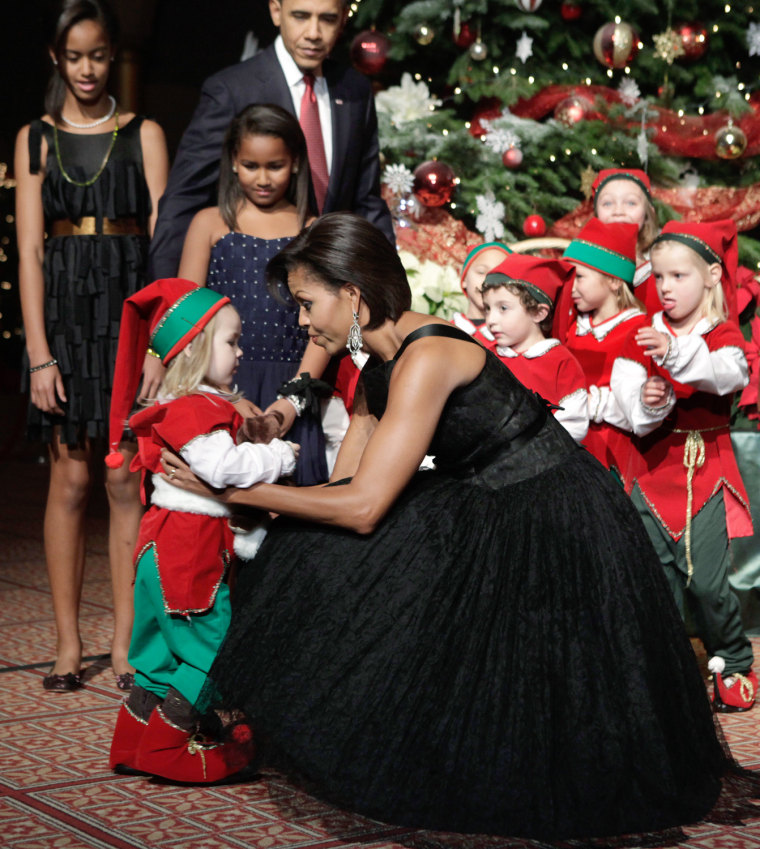 Image: U.S. first lady Michelle Obama greets a child dressed as an elf at the Christmas in Washington Celebration